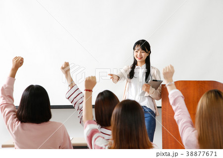 Campus life - female students in a classroom during class, studying together and taking selfie through mobile phone. 253 Campus life - female students in a classroom during class, studying together and taking selfie through mobile phone. 253 38877671