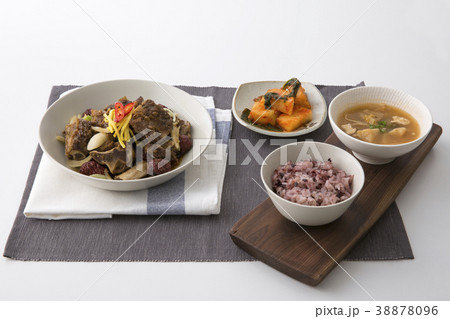 Delicious Korean food - kind of noodles, soup with rice and side dish with fish on the table. 102 38878096