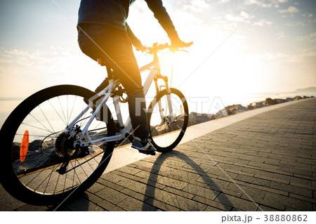 cyclist riding bike in the sunrise coast path 38880862