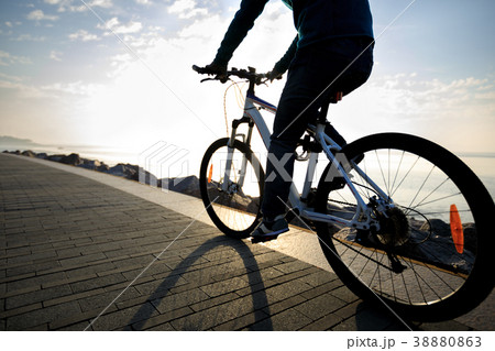 cyclist riding bike in the sunrise coast path 38880863