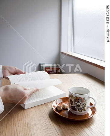 読書中の女性手元アップ コーヒーとお菓子 読書中の女性手元アップ コーヒーとお菓子 38881696