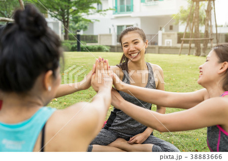 Group of sports women give each other high five Group of sports women give each other high five 38883666