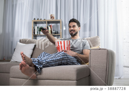 Happy man enjoying movie at home Happy man enjoying movie at home 38887728