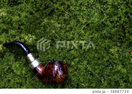 tobacco pipe on a green grass background. copy tobacco pipe on a green grass background. copy 38887739