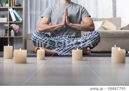 Peaceful guy meditating in living room 38887795