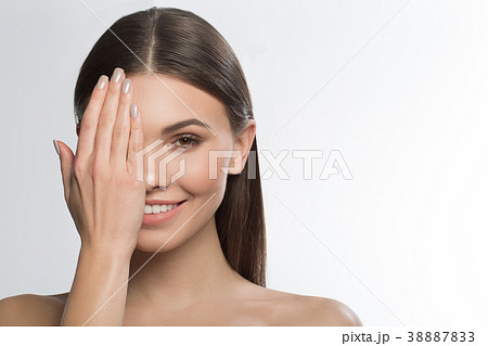 Cheerful girl covering pure face by hand Cheerful girl covering pure face by hand 38887833