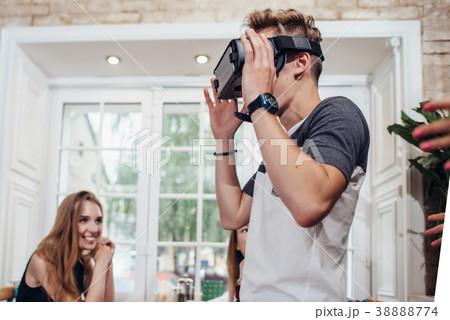Young man trying virtual reality glasses while Young man trying virtual reality glasses while 38888774
