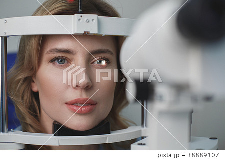 Focused woman checking eyes in ophthalmological 38889107