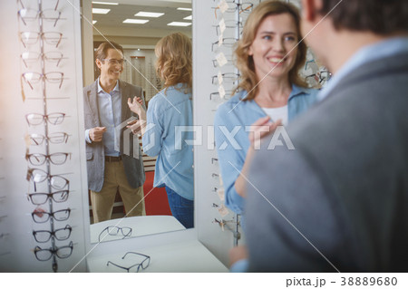 Beaming couple speaking in optician shop Beaming couple speaking in optician shop 38889680