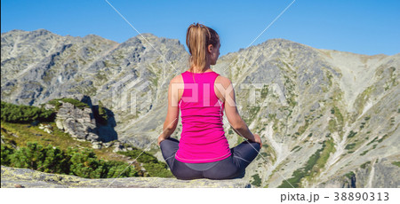 young woman meditate on top of the mountain 38890313