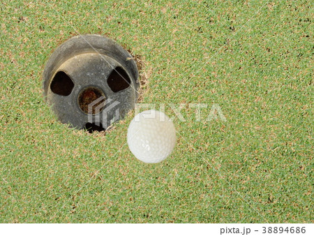 golf ball rolling near hole in course field golf ball rolling near hole in course field 38894686