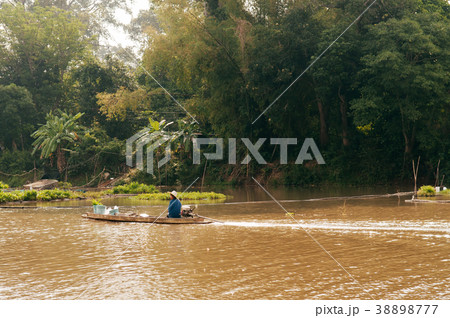 Asian fisherman on wooden longtail boat in river 38898777