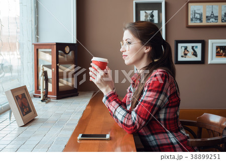 Girl student in a plaid shirt and glasses, in the 38899251