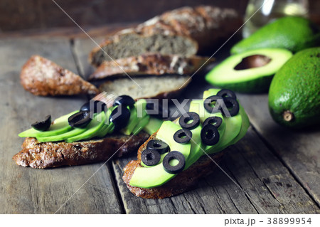 avocado bread olives on a wooden background 38899954
