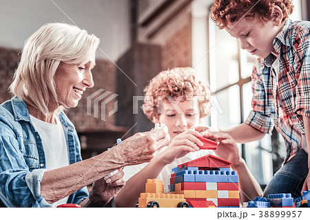 Joyful aged woman playing with her grandchildren 38899957