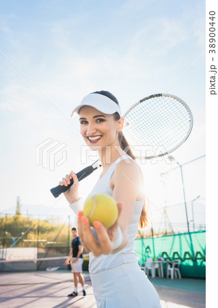 Woman going about playing Tennis 38900440
