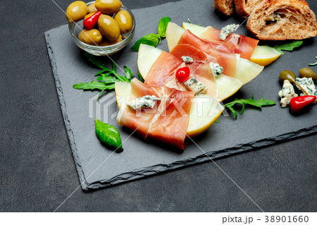 italian food with melon and prosciutto on stone italian food with melon and prosciutto on stone 38901660