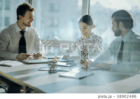 Cheerful boss joking with his colleagues during 38902486