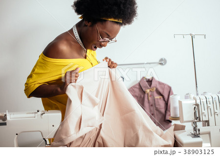 african woman seamstress looking at pink fabrics african woman seamstress looking at pink fabrics 38903125