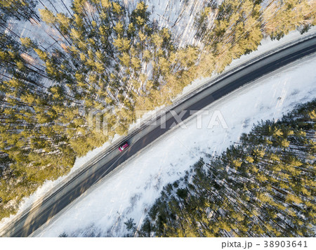 Snowy road with a moving car in winter 38903641