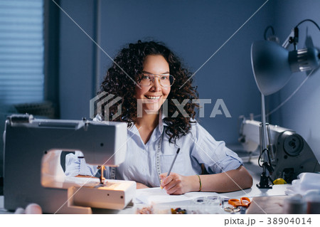 lefty dressmaker preparing a draft of garment in 38904014