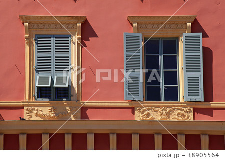 Ornate windows with grey shutters in old red house 38905564