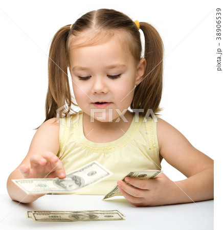 Cute cheerful little girl is counting dollars Cute cheerful little girl is counting dollars 38906539