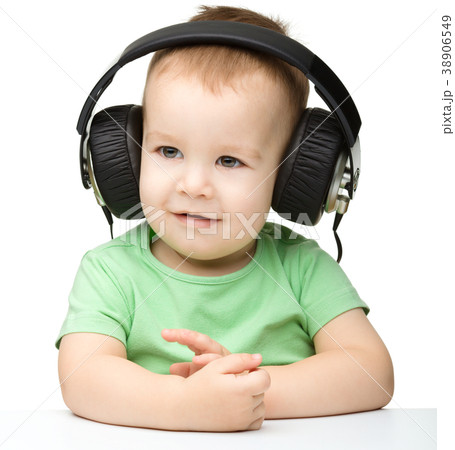 Cute little boy enjoying music using headphones Cute little boy enjoying music using headphones 38906549