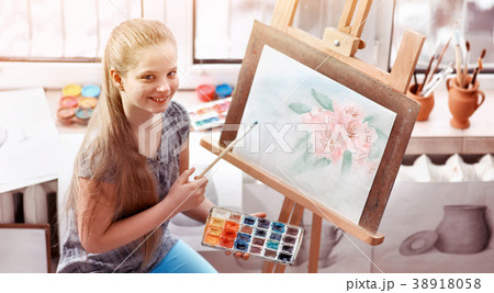 Artist painting on easel in studio. Girl paints Artist painting on easel in studio. Girl paints 38918058