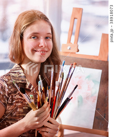 Artist painting on easel in studio. Girl paints Artist painting on easel in studio. Girl paints 38918073