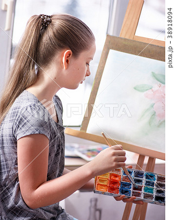 Artist painting on easel in studio. Girl paints 38918094