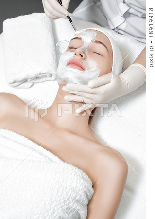 beautician applies mask to the face of woman beautician applies mask to the face of woman 38919918