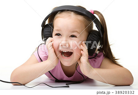 Cute little girl enjoying music using headphones Cute little girl enjoying music using headphones 38920332