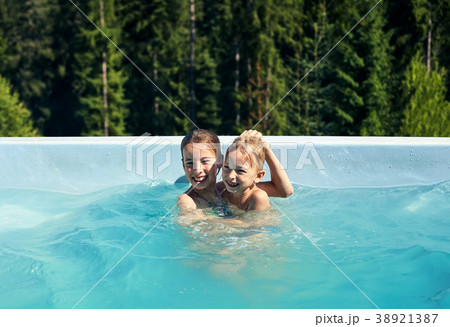 Portrait of brother and sister fooling around in outdoor pool Portrait of brother and sister fooling around in outdoor pool 38921387