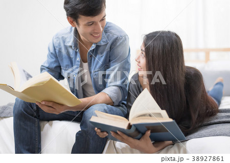 Young couple relaxing at home reading a book. Young couple relaxing at home reading a book. 38927861