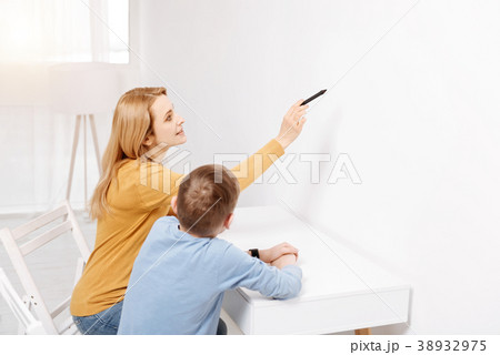 Joyful smart woman pointing at the wall 38932975