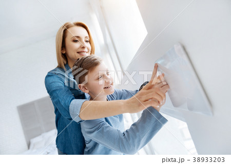 Pleasant happy woman holding her sons hand Pleasant happy woman holding her sons hand 38933203