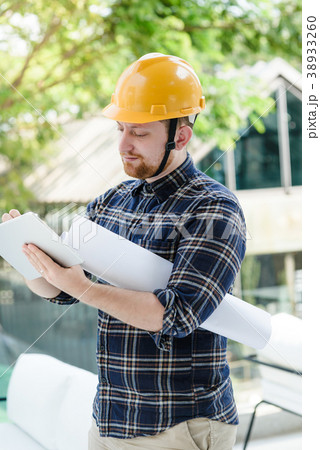 Male engineer at a construction site with a tablet 38933260