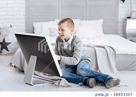 Delighted happy child sitting in front of the Delighted happy child sitting in front of the 38933307