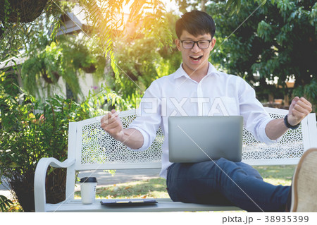 Business man with laptop working on the outdoor garden. Freelanc Business man with laptop working on the outdoor garden. Freelanc 38935399