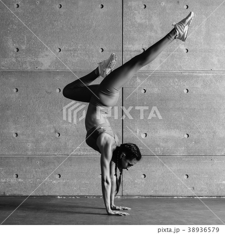 Young fit woman doing handstand exercise in studio Young fit woman doing handstand exercise in studio 38936579