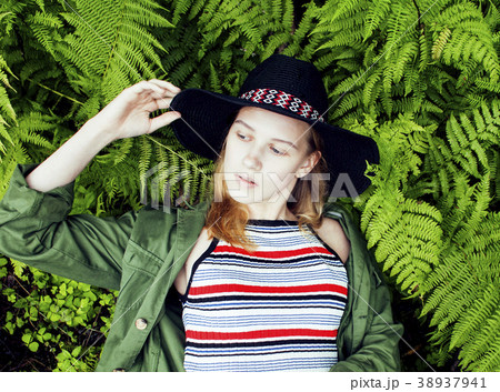 Pretty young blond girl hipster in hat among fern Pretty young blond girl hipster in hat among fern 38937941