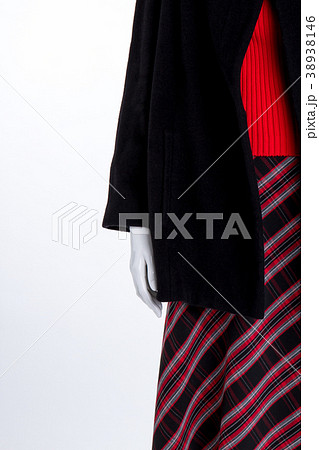 Close up black coat and striped skirt. 38938146