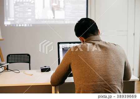 man freelancer in a sweater working on a laptop 38939669