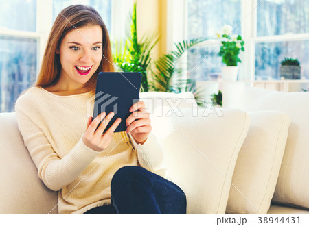 Young woman reading with an e-reader in a large 38944431