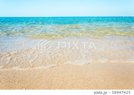 Soft waves with foam of blue ocean on the beach 38947425