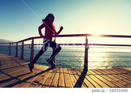 sporty runner running on seaside boardwalk sporty runner running on seaside boardwalk 38950306