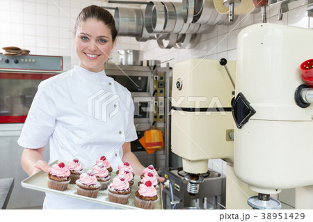 Proud confectioner showing muffins she baked Proud confectioner showing muffins she baked 38951429