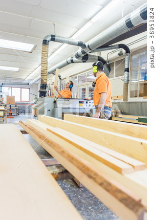Carpenter or joiner working on logs in his 38951824
