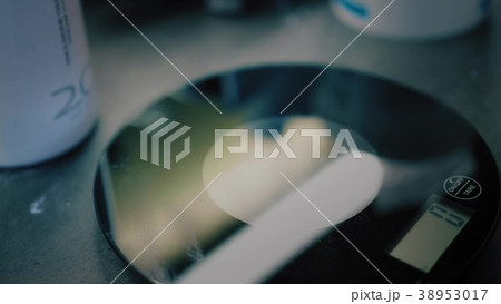 Hairdresser in black gloves puts a measuring bowl 38953017